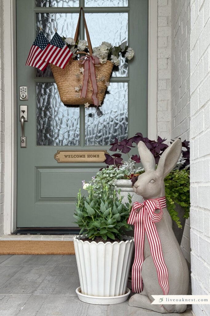 Patriotic Front Door Decor That Feels Cozy & Timeless, Small porch July 4th Decor, Basket of flowers on front door, americana porch decor from Live Oak Nest www.liveoaknest.com