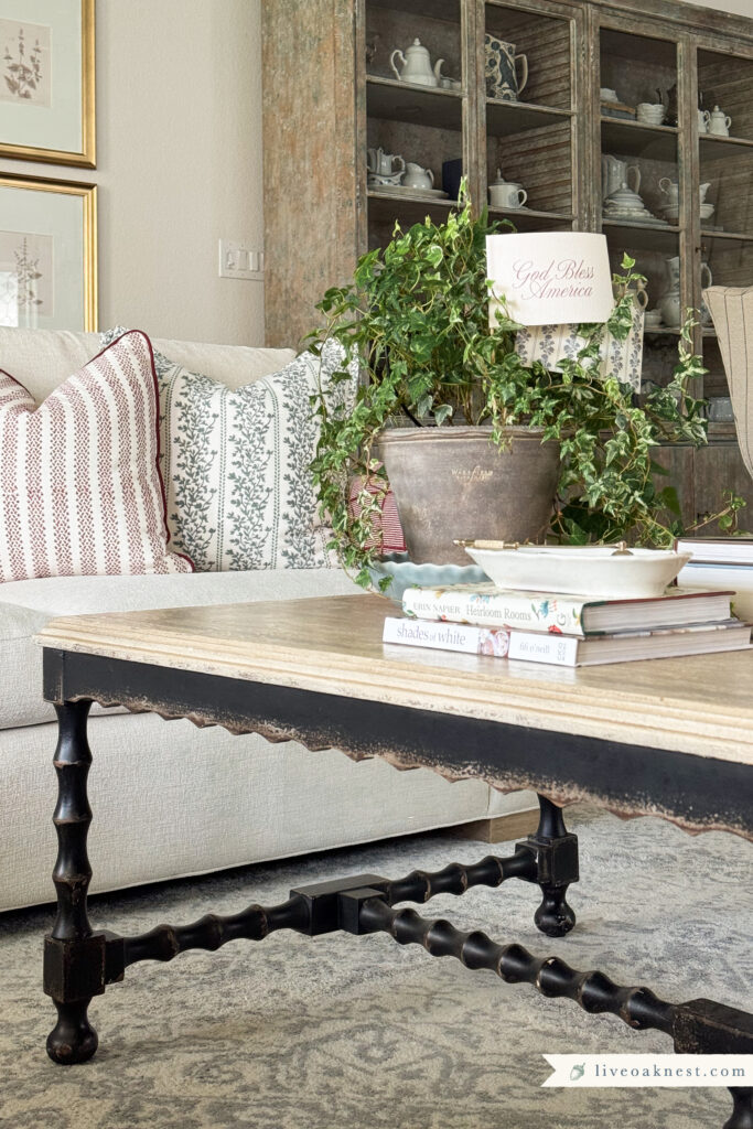 Timeless Patriotic Decor with Block Print Pillow covers in muted blue and red. Americana Coffee Table Styling with DIY Handmade Flags for Planters
